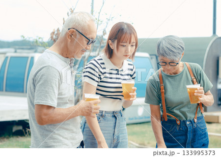 海辺で親子三人が立ち乾杯するシーン 海辺で親子三人が立ち乾杯するシーン 133995373