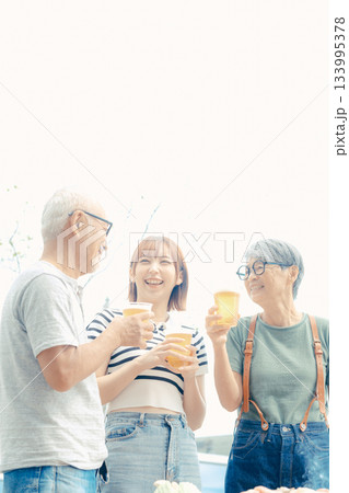 海辺で親子三人が立ち乾杯するシーン 海辺で親子三人が立ち乾杯するシーン 133995378