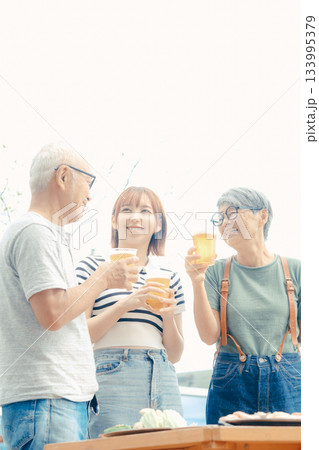 海辺で親子三人が立ち乾杯するシーン 海辺で親子三人が立ち乾杯するシーン 133995379