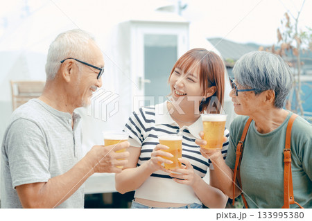 海辺で親子三人が立ち乾杯するシーン 海辺で親子三人が立ち乾杯するシーン 133995380
