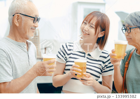 海辺で親子三人が立ち乾杯するシーン 海辺で親子三人が立ち乾杯するシーン 133995382