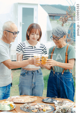 海辺で親子三人が立ち乾杯するシーン 133995383