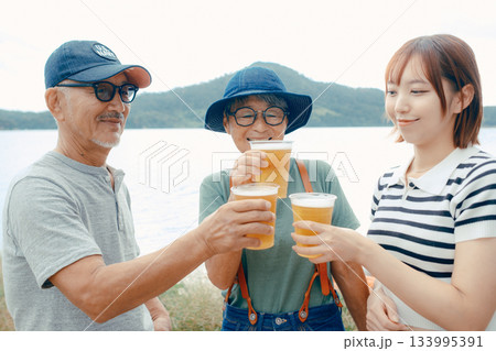 海辺で親子三人が立ち乾杯するシーン 海辺で親子三人が立ち乾杯するシーン 133995391