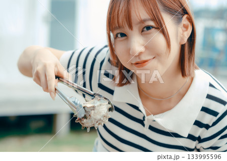 海辺で海鮮を焼く20代女性 133995596