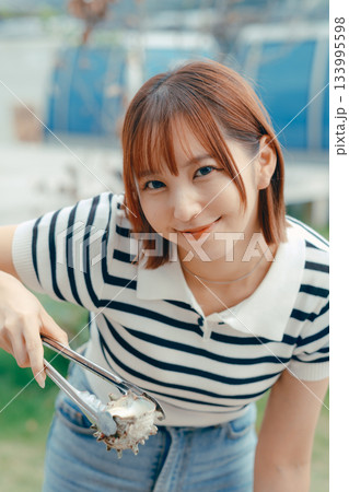 海辺で海鮮を焼く20代女性 海辺で海鮮を焼く20代女性 133995598