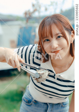 海辺で海鮮を焼く20代女性 133995602