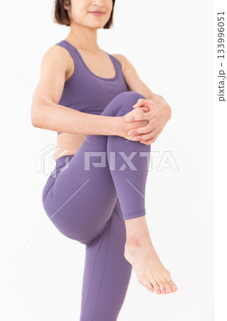 ストレッチ体操をするヨガウェア姿のミドル女性 133996051