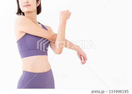 ストレッチ体操をするヨガウェア姿のミドル女性 133996195