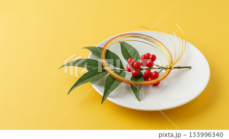 黄色い背景に南天と水引の梅結びが置かれた和風お正月イメージ 黄色い背景に南天と水引の梅結びが置かれた和風お正月イメージ 133996340