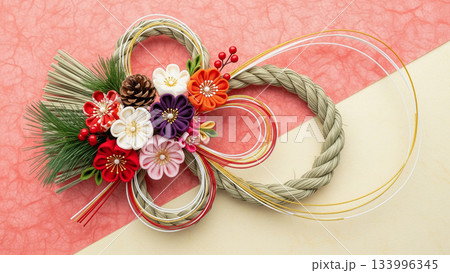 ピンクの背景にしめ縄飾りと水引が置かれた華やかなお正月構図 133996345