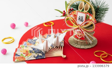 赤背景に扇子と正月飾りを置いた上余白ありの新年イメージ素材 赤背景に扇子と正月飾りを置いた上余白ありの新年イメージ素材 133996379