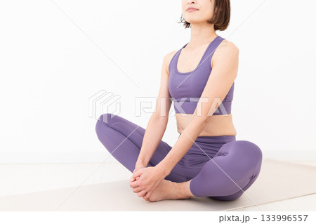 ストレッチ体操をするヨガウェア姿のミドル女性 ストレッチ体操をするヨガウェア姿のミドル女性 133996557