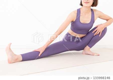 ストレッチ体操をするヨガウェア姿のミドル女性 133998146
