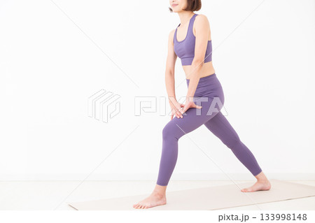 ストレッチ体操をするヨガウェア姿のミドル女性 133998148