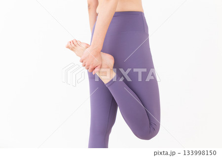 ストレッチ体操をするヨガウェア姿のミドル女性 133998150