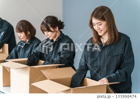 ダンボールに梱包作業をする運送・物流・宅急便・宅配便・流通・配達・倉庫・宅配業者の作業員の男女 133998474