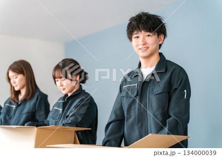 ダンボールに箱詰めする運送・物流・宅急便・宅配便・流通・配達・宅配業者の作業員の男女 134000039