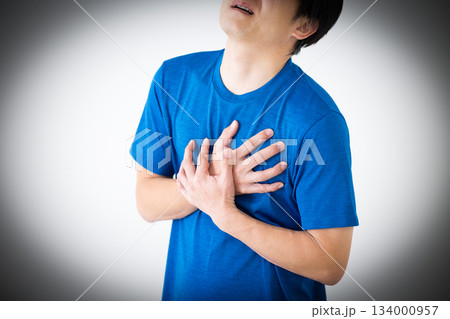 胸の痛みに苦しむTシャツ姿のミドル男性 134000957