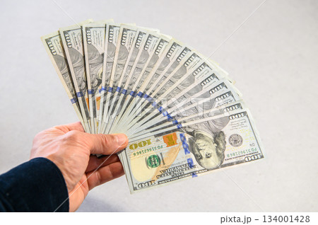 米100ドル紙幣17枚を扇状に広げて左手で差し出すピントクッキリ 134001428