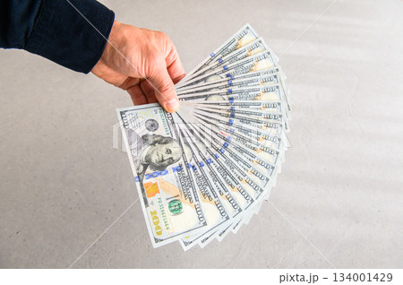 米100ドル紙幣18枚を扇状に広げて左手で左方向から差し出す 米100ドル紙幣18枚を扇状に広げて左手で左方向から差し出す 134001429