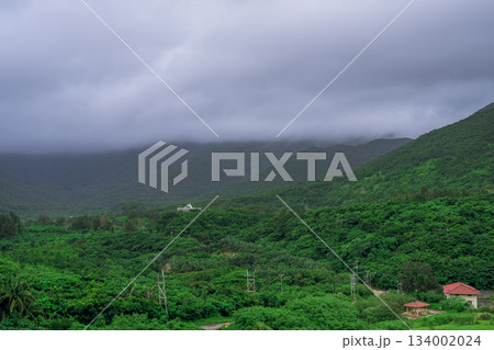 梅雨空の下で広がる名蔵ダム周辺の緑豊かな山々の風景 134002024