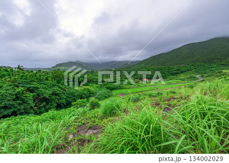 梅雨空の下で広がる名蔵ダム周辺の緑豊かな山々の風景 134002029