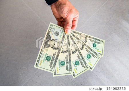 米20ドル紙幣5枚を左手で扇状に広げ奥から手前に差し出すアングルショット2 134002286