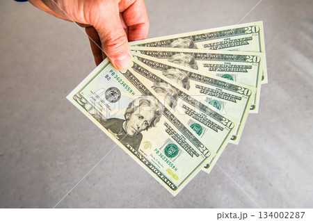 米20ドル紙幣5枚を左手で扇状に広げ奥から手前に差し出すアングルクローズアップショット 米20ドル紙幣5枚を左手で扇状に広げ奥から手前に差し出すアングルクローズアップショット 134002287