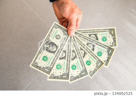 米1ドル紙幣6枚を左手で扇状に広げ奥から手前に差し出すアングルショット2 米1ドル紙幣6枚を左手で扇状に広げ奥から手前に差し出すアングルショット2 134002525