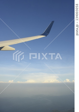 アメリカ　デトロイト空港離陸後の上空からの翼と空と雲 134003058