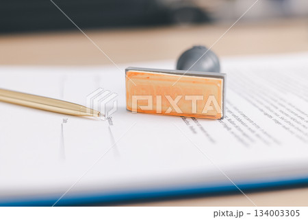 Close up approved stamp on signed document with pen on desk, concept of successful business contract, legal authorization, agreement approval or financial verification process. approved stamp 134003305