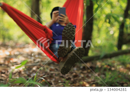 Relaxing in hammock in tropical forest Relaxing in hammock in tropical forest 134004281
