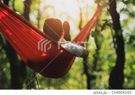 Relaxing in hammock in tropical forest Relaxing in hammock in tropical forest 134004283