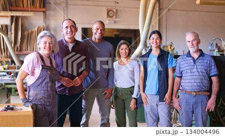 Diverse team of smiling factory workers standing in workshop Diverse team of smiling factory workers standing in workshop 134004496