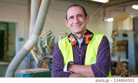 Smiling experienced carpenter worker with folded arms 134004501