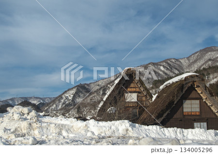 雪に埋もれた合掌造り民家と雪山の冬の風景 雪に埋もれた合掌造り民家と雪山の冬の風景 134005296
