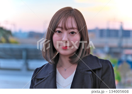 屋上で夕焼け空を見上げる女性 屋上で夕焼け空を見上げる女性 134005608