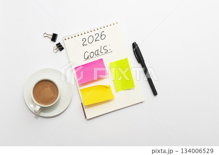 Minimal workspace with notebook, colorful sticky notes, pen, binder clips and coffee cup on white background, top view Minimal workspace with notebook, colorful sticky notes, pen, binder clips and coffee cup on white background, top view 134006529