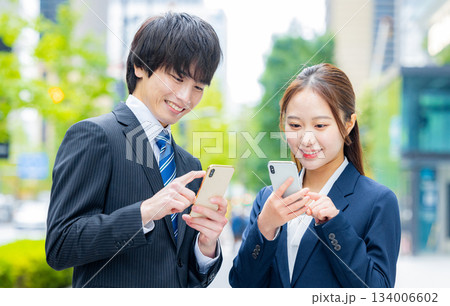 スマホを使うビジネスマンとビジネスウーマン 134006602