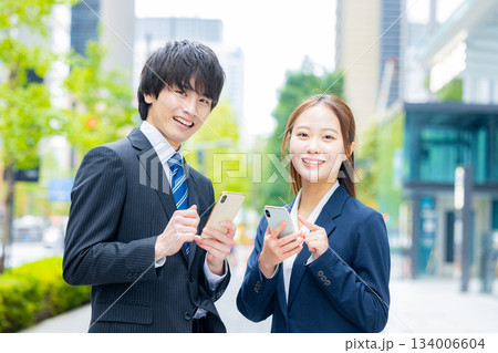 スマホを使うビジネスマンとビジネスウーマン 134006604