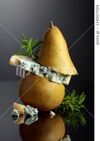 Blue cheese with pear and rosemary on a black background. 134007004