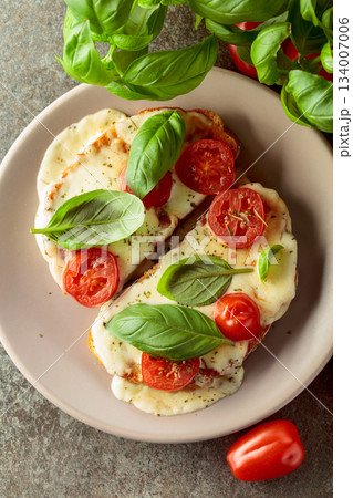 Hot open sandwiches with mozzarella, tomatoes and basil. 134007006