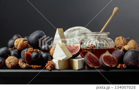Soft cheese with fruits on a black background. 134007028