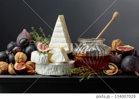 Soft cheeses with fruits on a black background. Soft cheeses with fruits on a black background. 134007029