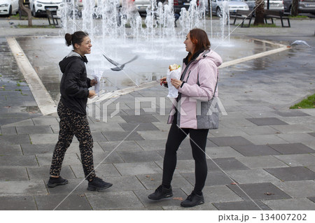 two girl friends having fun with street food in europe, lifestyle people concept two girl friends having fun with street food in europe, lifestyle people concept 134007202