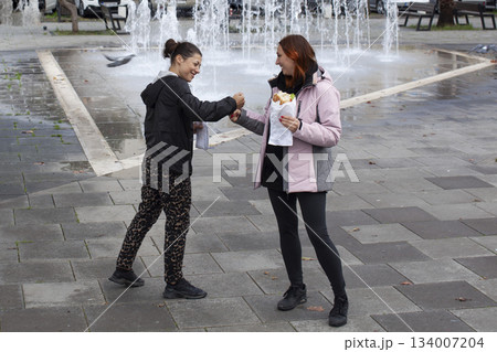 two girl friends having fun with street food in europe, lifestyle people concept two girl friends having fun with street food in europe, lifestyle people concept 134007204