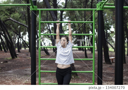 young pretty brunette woman outside making sport exercises on training playground, lifestyle people concept 134007270