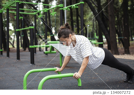 young pretty brunette woman outside making sport exercises on training playground, lifestyle people concept 134007272
