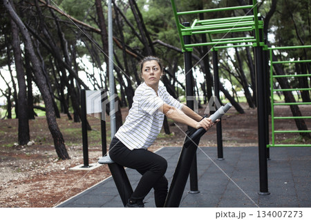 young pretty brunette woman outside making sport exercises on training playground, lifestyle people concept young pretty brunette woman outside making sport exercises on training playground, lifestyle people concept 134007273