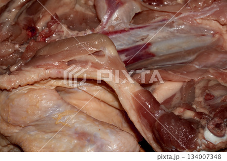 Close up of meat carcass tendons and bones from a chicken that has been carved horror blood red background food waste Close up of meat carcass tendons and bones from a chicken that has been carved horror blood red background food waste 134007348